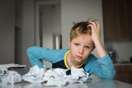 Tired and stressed-looking boy struggling with homework could benefit from Fit Learning's research-based approach to anxiety-free learning
