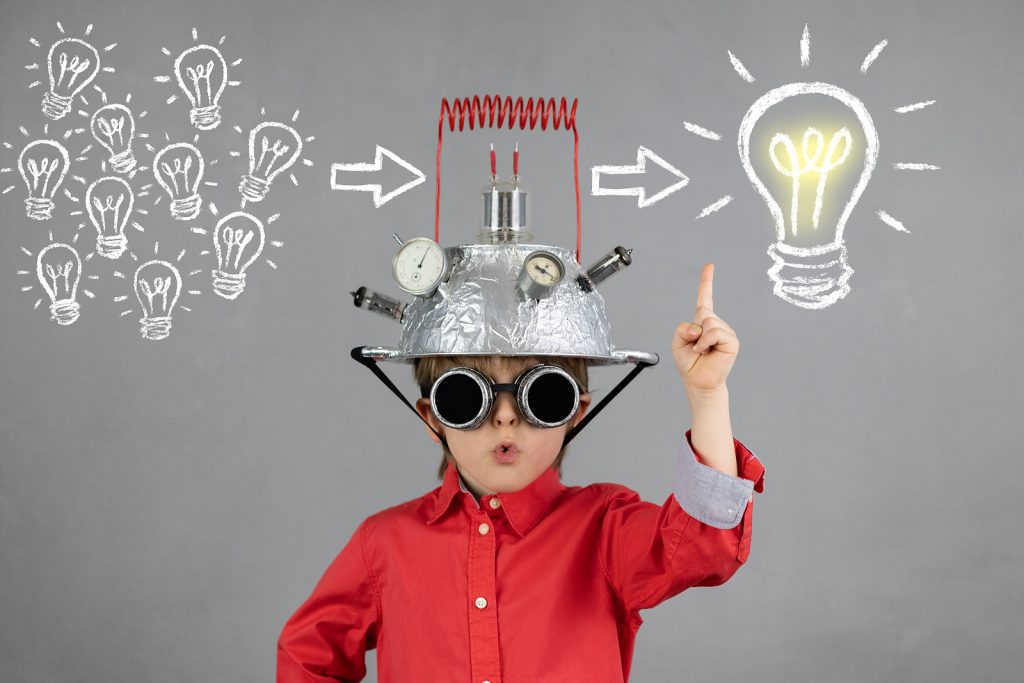 Image of elementary boy with thinking cap by drawings of lightbulbs. Searching for help for children with ADHD in St. Louis, MO? Fit Learning can help this summer with academic summer camp near MICDS 63124.