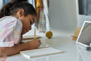 Child working on homework representing a learning with slow processing speed from the St. Louis area who's parents have brought her to our Creve Coeur learning lab to catch up on math and continue learning to read. 