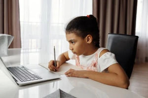 A child concentrating on both the computer and writing, representing a child participating in our online tutoring for math, reading, logic & more. Our tutoring strategies are perfect for students with ADHD, slow processing speed, autism, anxiety, and a variety of learning disabilities. We offer in person tutoring at our Creve Coeur learning lab in addition to online tutoring.
