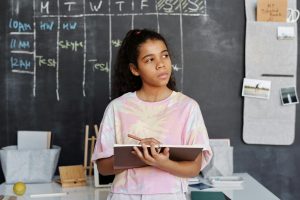 Unsure-looking girl in classroom whose confidence would benefit from Fit Learning's approach to tutoring