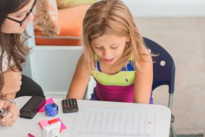child looks at words on a piece of paper while she gets reading help from a reading tutor in Creve Coeur, MO at Fit Learning Saint Louis 63141